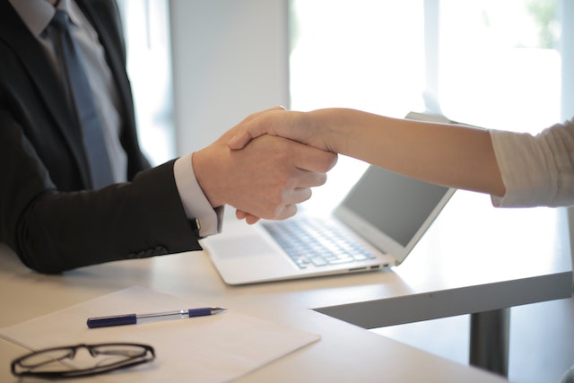 two people in suits shaking hands